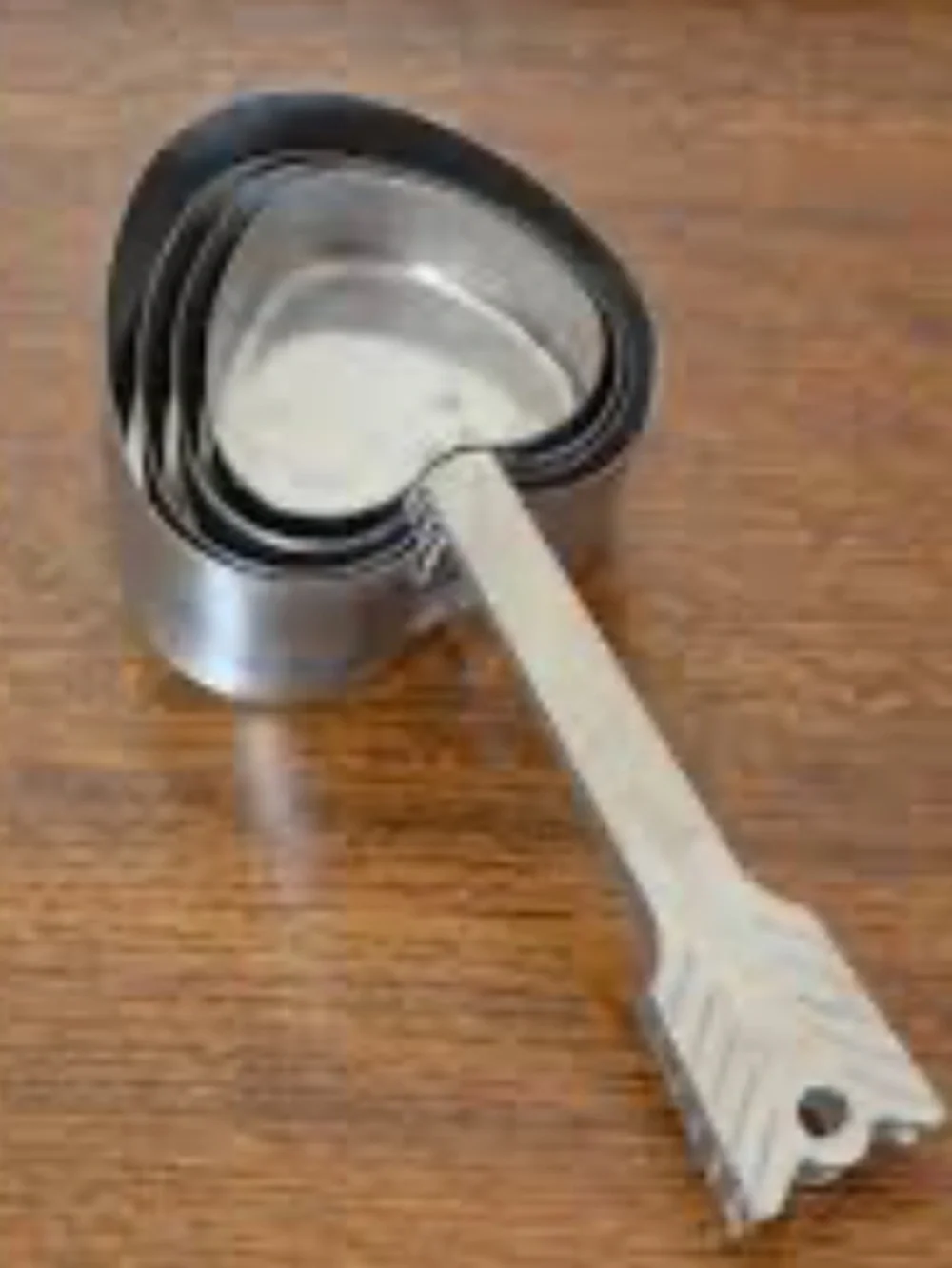 Beehive Handmade stainless steel nesting heart-and-arrow measuring cups.